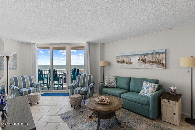 2000 New River Inlet Rd Unit 3513, North Topsail Beach, NC 28460 - tiled living room featuring a textured ceiling, a water view, and a wall of windows