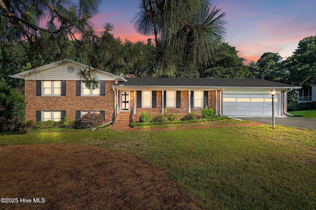 306 Mclean St, Hamlet, NC 28345 - tri-level home with driveway, brick siding, a garage, a front lawn, and a chimney