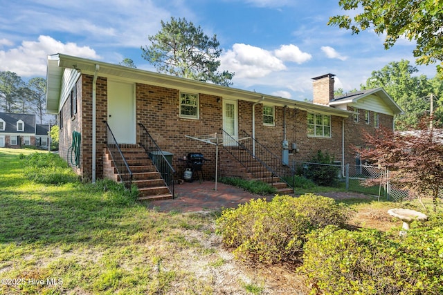 306 Mclean St, Hamlet, NC 28345 - view of front facade with a chimney, entry steps, and brick siding