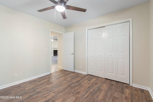 3 Gate 11, Carolina Shores, NC 28467 - unfurnished bedroom with wood finished floors, a closet, a ceiling fan, and a fireplace