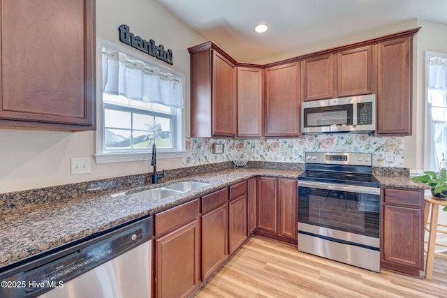 463 Avendale Dr, Rocky Point, NC 28457 - kitchen featuring stainless steel appliances, light wood-style flooring, dark stone countertops, brown cabinets, and recessed lighting