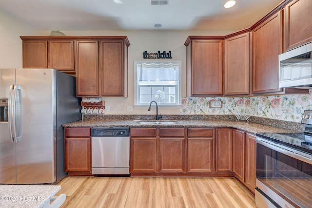 463 Avendale Dr, Rocky Point, NC 28457 - kitchen with stainless steel appliances, light wood-style floors, brown cabinets, and recessed lighting
