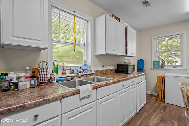 1106 E Stewart Cir, Wilmington, NC 28405 - kitchen with fridge, black microwave, white cabinets, and wood finished floors