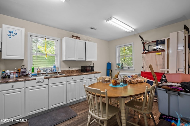 1106 E Stewart Cir, Wilmington, NC 28405 - kitchen with black microwave, dark wood-type flooring, and white cabinets