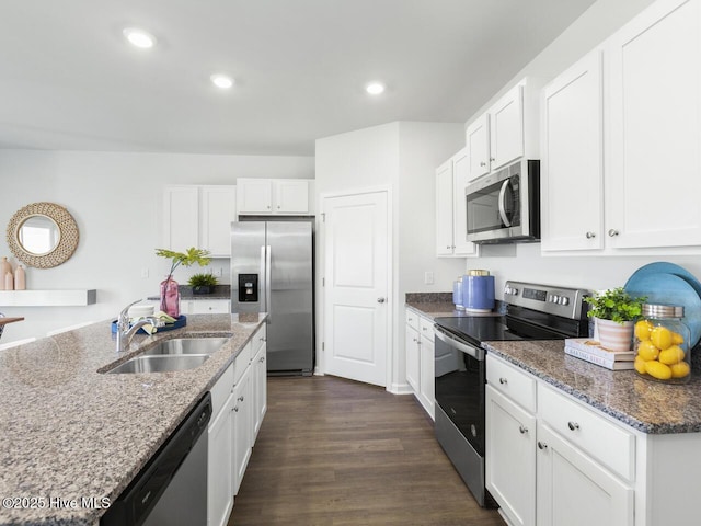 112 Edgewater Way Unit 57, Surf City, NC 28445 - kitchen with stainless steel appliances, dark wood finished floors, white cabinetry, recessed lighting, and dark stone counters