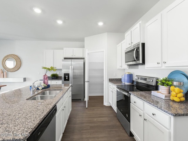112 Edgewater Way Unit 57, Surf City, NC 28445 - kitchen with appliances with stainless steel finishes, dark wood-style flooring, white cabinets, recessed lighting, and dark stone counters