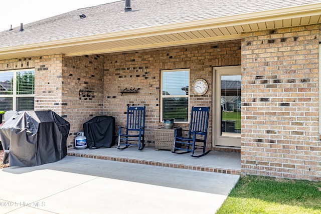 112 Mergini Dr, Pikeville, NC 27863 - doorway to property with a shingled roof, brick siding, and a patio area
