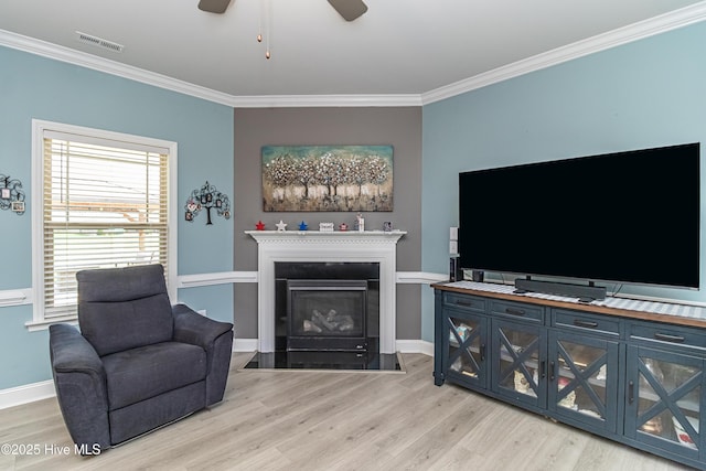 112 Mergini Dr, Pikeville, NC 27863 - living room featuring light wood finished floors, crown molding, a ceiling fan, and a fireplace with flush hearth