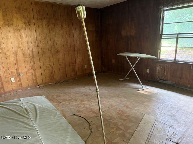 120 Bazemore Ln, Sunbury, NC 27979 - empty room with wood walls and light floors