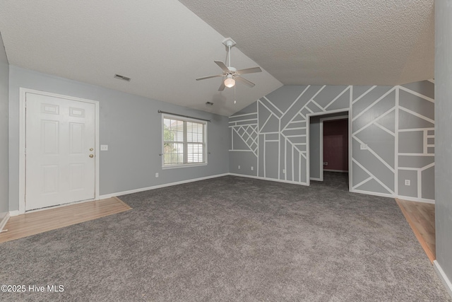 6723 Newbury Way, Wilmington, NC 28411 - unfurnished living room featuring a ceiling fan, carpet flooring, vaulted ceiling, and a textured ceiling