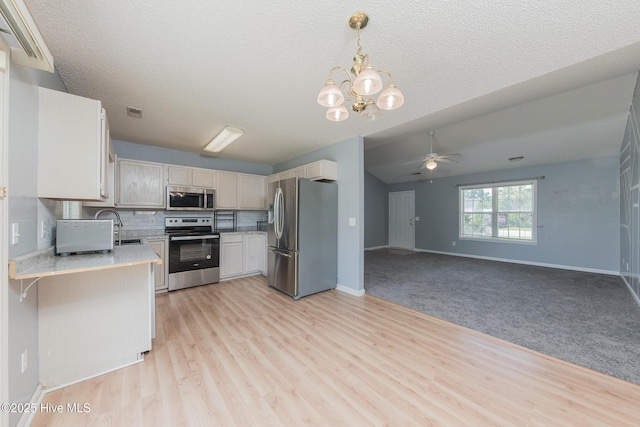 6723 Newbury Way, Wilmington, NC 28411 - kitchen with stainless steel appliances, light countertops, ceiling fan, a chandelier, and decorative backsplash