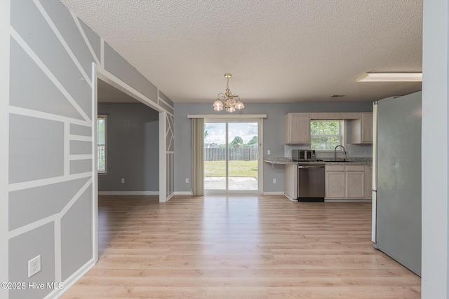 6723 Newbury Way, Wilmington, NC 28411 - kitchen with appliances with stainless steel finishes, a textured ceiling, a chandelier, light wood-style floors, and light countertops