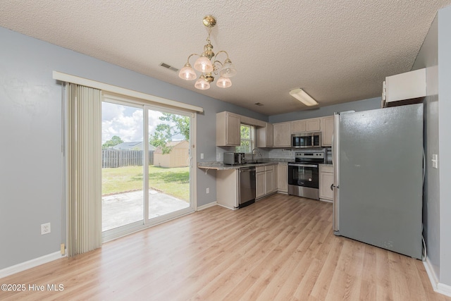 6723 Newbury Way, Wilmington, NC 28411 - kitchen with appliances with stainless steel finishes, light wood-style floors, light countertops, a chandelier, and a textured ceiling