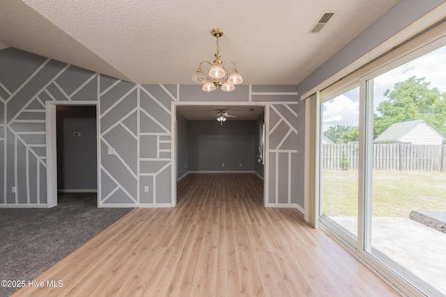 6723 Newbury Way, Wilmington, NC 28411 - unfurnished dining area featuring a chandelier, wood finished floors, ceiling fan, and a textured ceiling