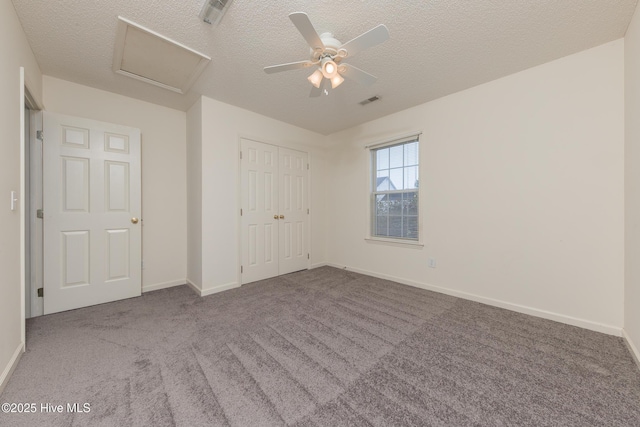 6723 Newbury Way, Wilmington, NC 28411 - unfurnished bedroom featuring attic access, carpet floors, a textured ceiling, a closet, and a ceiling fan
