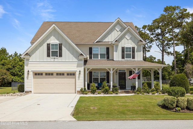 400 Lanyard Dr, Newport, NC 28570 - view of front of house with board and batten siding, covered porch, an attached garage, concrete driveway, and a front lawn