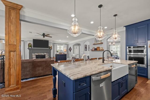 400 Lanyard Dr, Newport, NC 28570 - kitchen with stainless steel appliances, blue cabinets, a fireplace, crown molding, and ceiling fan
