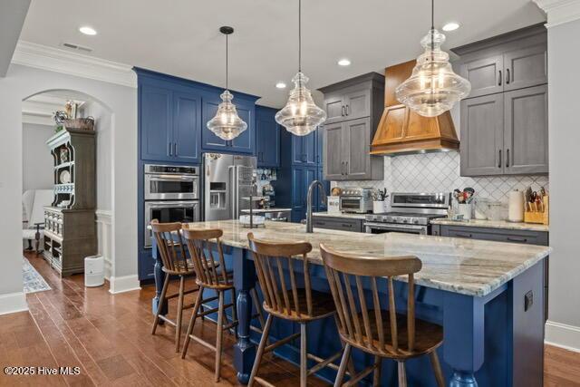400 Lanyard Dr, Newport, NC 28570 - kitchen with appliances with stainless steel finishes, backsplash, an island with sink, ornamental molding, and light stone counters