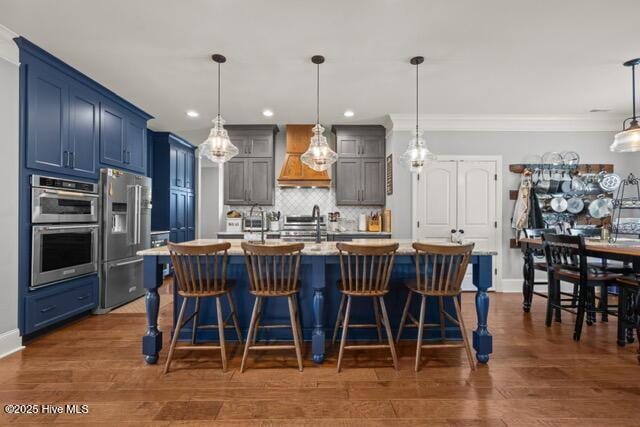400 Lanyard Dr, Newport, NC 28570 - kitchen with appliances with stainless steel finishes, premium range hood, backsplash, light countertops, and a breakfast bar