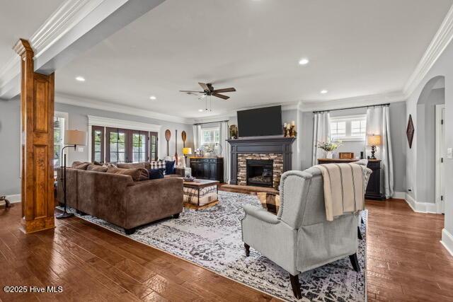400 Lanyard Dr, Newport, NC 28570 - living area with ceiling fan, ornamental molding, a stone fireplace, arched walkways, and dark wood finished floors