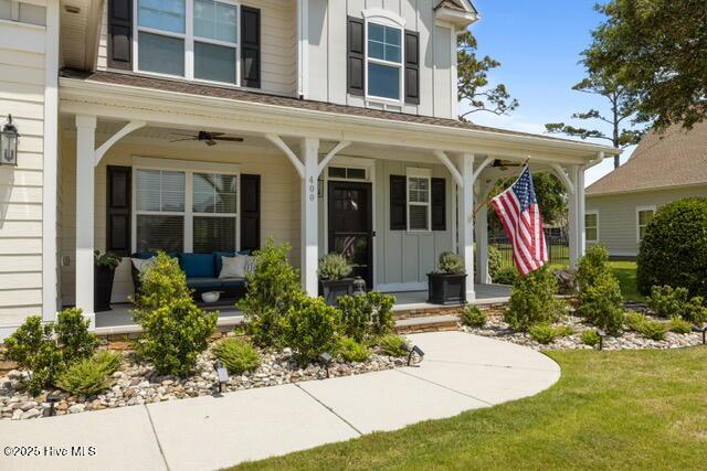 400 Lanyard Dr, Newport, NC 28570 - view of exterior entry with board and batten siding, covered porch, a ceiling fan, and a yard