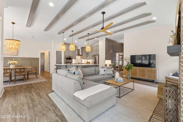 1112 Winged Seed Way, Wilmington, NC 28409 - living area featuring light wood finished floors, a chandelier, a ceiling fan, a decorative wall, and a wainscoted wall