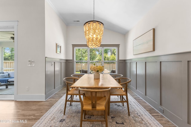 1112 Winged Seed Way, Wilmington, NC 28409 - dining area with a chandelier, wood finished floors, a decorative wall, a wainscoted wall, and vaulted ceiling