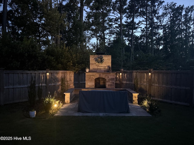 1112 Winged Seed Way, Wilmington, NC 28409 - fenced backyard featuring an outdoor stone fireplace and a patio