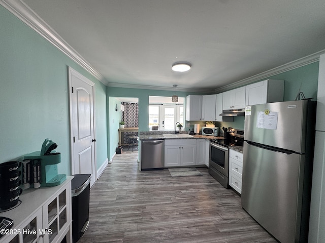 123 Cedar Point Blvd, Cedar Point, NC 28584 - kitchen with appliances with stainless steel finishes, crown molding, white cabinets, under cabinet range hood, and dark wood-style flooring