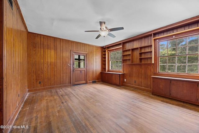 1200 W Lenoir Ave, Kinston, NC 28501 - unfurnished room with wooden walls, wood finished floors, ceiling fan, healthy amount of natural light, and ornamental molding
