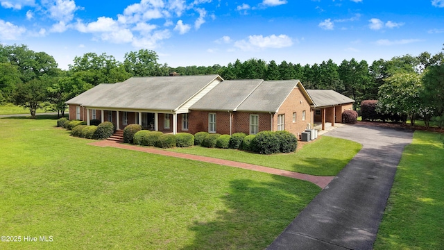 3509 Lakeview Trl, Kinston, NC 28504 - view of front of home featuring brick siding, a front lawn, a chimney, and view of wooded area