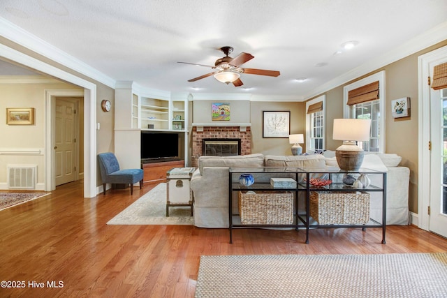 3509 Lakeview Trl, Kinston, NC 28504 - living area featuring a ceiling fan, ornamental molding, wood finished floors, a fireplace, and built in shelves
