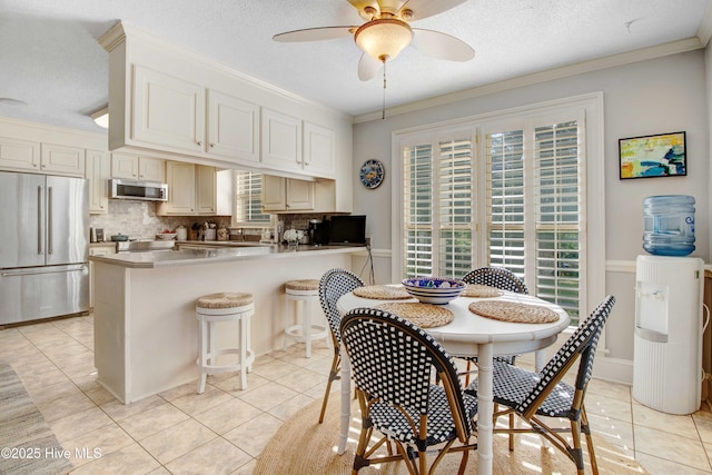 3509 Lakeview Trl, Kinston, NC 28504 - dining space with light tile patterned flooring, a ceiling fan, crown molding, and a textured ceiling