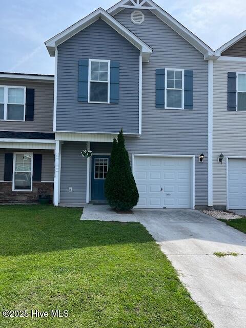 304 Cedar Island Trl, Holly Ridge, NC 28445 - townhome / multi-family property with driveway, an attached garage, and a front yard