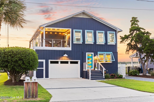 15 Coral Dr, Wrightsville Beach, NC 28480 - view of front facade featuring a balcony, an attached garage, concrete driveway, and a front lawn