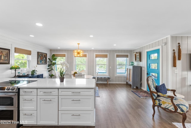 15 Coral Dr, Wrightsville Beach, NC 28480 - kitchen with range with two ovens, wood finished floors, light countertops, white cabinets, and plenty of natural light