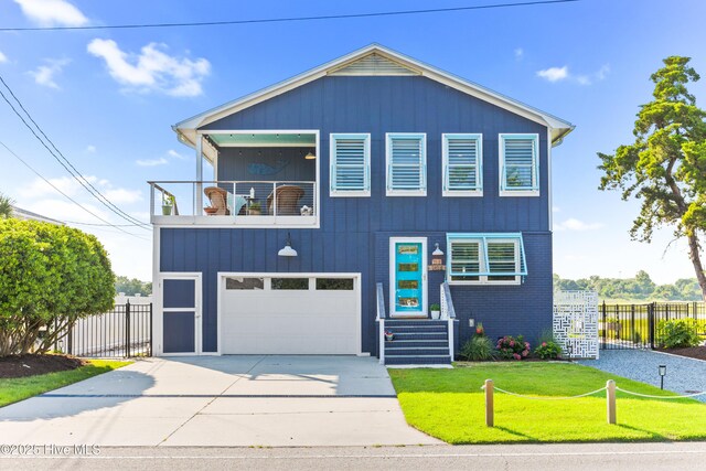 15 Coral Dr, Wrightsville Beach, NC 28480 - view of front facade featuring a balcony, driveway, and an attached garage