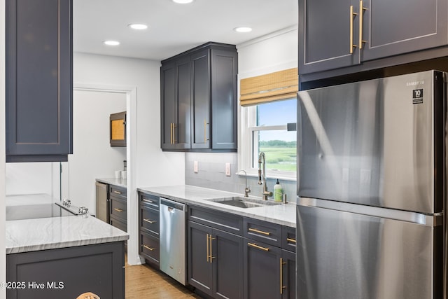 15 Coral Dr, Wrightsville Beach, NC 28480 - kitchen featuring appliances with stainless steel finishes, light stone countertops, light wood-style flooring, recessed lighting, and decorative backsplash