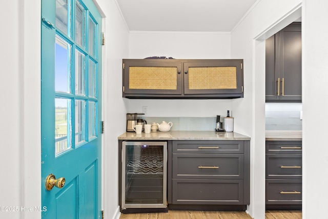 15 Coral Dr, Wrightsville Beach, NC 28480 - indoor dry bar with beverage cooler, ornamental molding, healthy amount of natural light, light wood finished floors, and backsplash