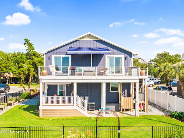 15 Coral Dr, Wrightsville Beach, NC 28480 - view of front facade with a balcony, a fenced backyard, stairway, and board and batten siding