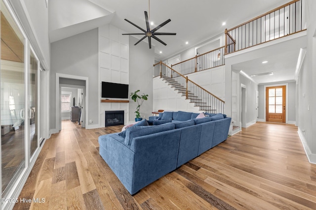 28 Kahkwa Trl, Pinehurst, NC 28374 - living area with high vaulted ceiling, light wood-style floors, stairs, a ceiling fan, and a large fireplace