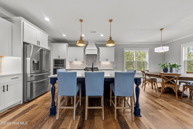 28 Kahkwa Trl, Pinehurst, NC 28374 - kitchen featuring appliances with stainless steel finishes, ornamental molding, light countertops, light wood-style flooring, and backsplash