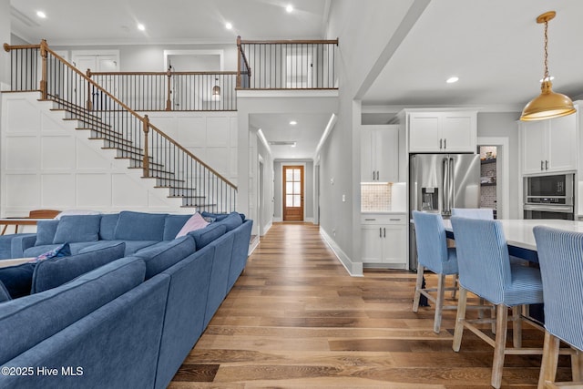 28 Kahkwa Trl, Pinehurst, NC 28374 - living area featuring ornamental molding, light wood-type flooring, recessed lighting, stairway, and a towering ceiling
