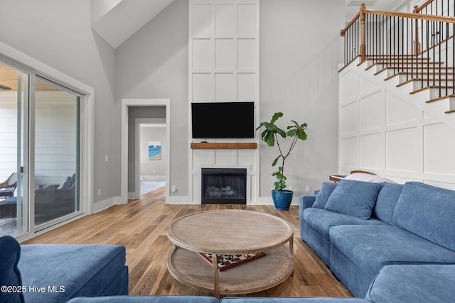 28 Kahkwa Trl, Pinehurst, NC 28374 - living area with high vaulted ceiling, wood finished floors, a fireplace, stairway, and healthy amount of natural light