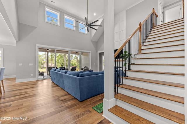 28 Kahkwa Trl, Pinehurst, NC 28374 - living area with ceiling fan, stairway, light wood-style floors, plenty of natural light, and a towering ceiling