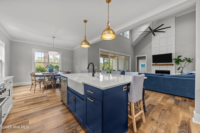 28 Kahkwa Trl, Pinehurst, NC 28374 - kitchen with blue cabinets, a breakfast bar, stainless steel dishwasher, ornamental molding, and light wood-type flooring