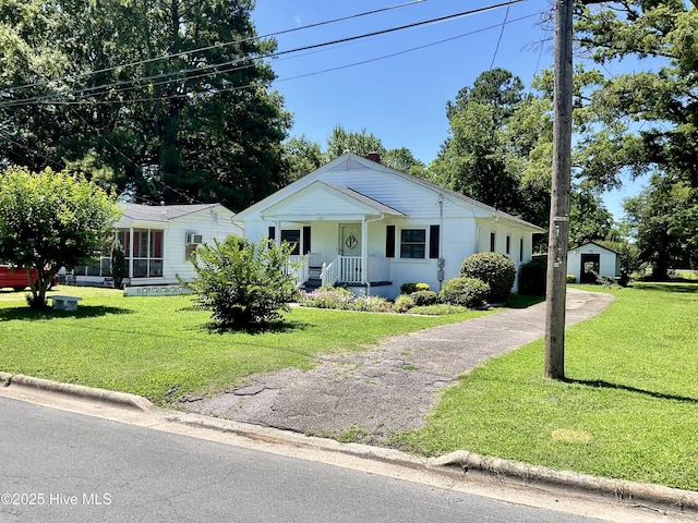 309 Battle Dr, Nashville, NC 27856 - bungalow featuring asphalt driveway, a porch, a front yard, and an outbuilding