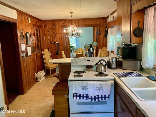309 Battle Dr, Nashville, NC 27856 - kitchen featuring electric stove, wooden walls, light countertops, a chandelier, and a peninsula