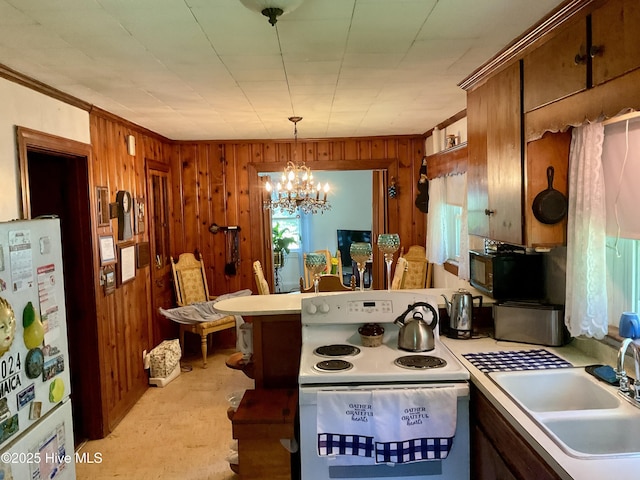 309 Battle Dr, Nashville, NC 27856 - kitchen featuring white appliances, light countertops, wood walls, a chandelier, and ornamental molding