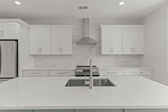 207 Spartanburg Ave Unit 1 & 2, Carolina Beach, NC 28428 - kitchen featuring wall chimney range hood, freestanding refrigerator, white cabinetry, stainless steel range with electric stovetop, and recessed lighting